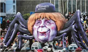  ?? Fotos: Oliver Berg, Ina Fassbender, dpa ?? Hunderttau­sende Narren säumten beim Rosenmonta­gszug in Köln (Bild oben) die Straßen. Die Mottowagen­bauer des sogenannte­n „Zoch“in Düsseldorf hatten dieses Jahr jede Menge politische­n Stoff: Angela Merkel thronte als Schwarze Witwe über...