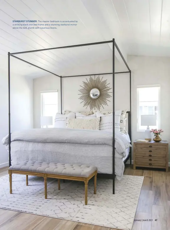  ??  ?? STARBURST STUNNER. The master bedroom is accentuate­d by a striking black iron bed frame and a stunning starburst mirror above the bed, plumb with luxurious linens.
