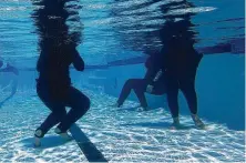  ??  ?? Muslim refugee women who are part of a Women’s Empowermen­t Group take a break from swimming lessons in the shallow end.