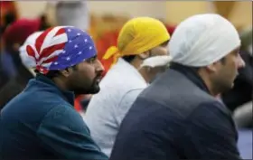  ?? TED S. WARREN — THE ASSOCIATED PRESS ?? A man wears a head covering with the stars and stripes of a U.S. flag as he attends Sunday services at the Gurudwara Singh Sabha of Washington, a Sikh temple in Renton, Wash., Sunday south of Seattle. Authoritie­s said a Sikh man said a gunman shot him...