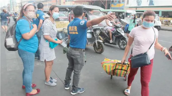  ?? PHOTOGRAPH BY JOEY SANCHEZ MENDOZA FOR THE DAILY TRIBUNE ?? BARANGAY officials keep an eye on shoppers in Ylaya, Divisoria for compliance with the protocol for the use of masks and face shields.