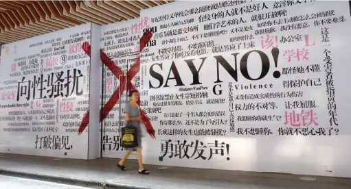  ??  ?? A woman walks past a mural of messages against sexual harassment in Xi’an, capital city of Shaanxi Province, August 9, 2018