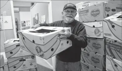  ?? JEREMY FRASER/CAPE BRETON POST ?? Robert Dolomont, a volunteer at the North Sydney Community Food Bank, lifts a box of non-perishable food items at the North Sydney location on Thursday. The local food bank has received overwhelmi­ng support after making a plea to the community for...