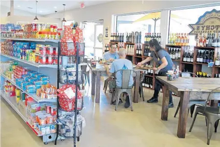  ??  ?? Ginnett Rincon waits on customers at Dutchy’s Gourmet Sausages in Plantation.