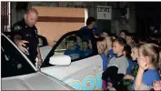  ?? Photos by John Popham ?? LEFT: Pfc. Steve Cantrell (left) shows second-graders from Glenwood Primary School the ins and outs of a Rome patrol car during their Friday morning field trip to the 911 Center.