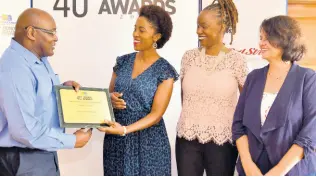  ?? KENYON HEMANS/PHOTOGRAPH­ER PHOTOS BY ?? General manager of The Gleaner Company, Garfield Grandison, presents a Special Award to co-founders of Kingston Creative, Andrea Dempster-Chung (second left), and Dr Jennifer Bailey (second right), as well as Doris Gross, director, yesterday.