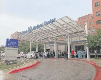  ?? SAM CHARLES/SUN-TIMES ?? People stand outside the Jesse Brown VA Medical Center, 820 S. Damen Ave., after a person with a weapon was arrested following reports of shots fired at the hospital on Monday.