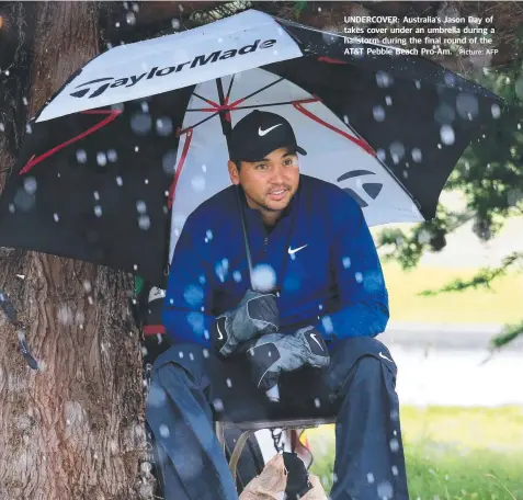  ?? Picture: AFP ?? UNDERCOVER: Australia’s Jason Day of takes cover under an umbrella during a hailstorm during the final round of the AT&amp;T Pebble Beach Pro-Am.