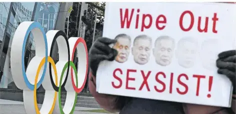  ?? FOTO: FONG/AFP ?? Ein Aktivist hält ein Plakat mit dem Bild von Japans Olympia-OK-Chef Yoshiro Mori hoch, das dessen Rücktritt wegen sexistisch­er Äußerungen fordert.