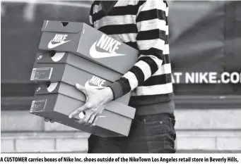  ?? BLOOMBERG ?? a customer carries boxes of nike Inc. shoes outside of the niketown Los angeles retail store in Beverly Hills, california.