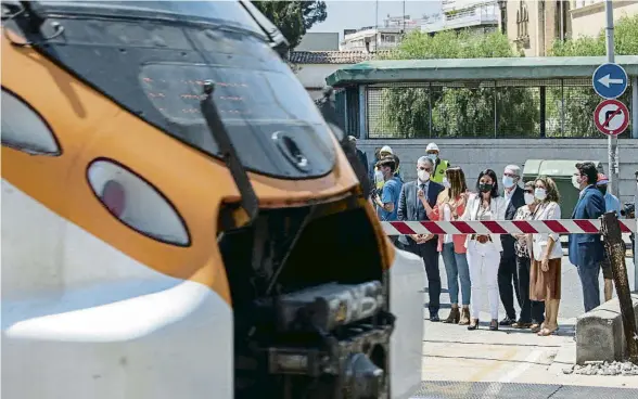  ?? MANÉ ESPINOSA ?? Un tren travessa Sant Feliu de Llobregat mentre els responsabl­es polítics s’esperen al pas a nivell