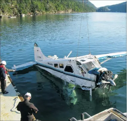  ?? — SUBMITTED PHOTO ?? Transporta­tion Safety Board officers haul a wrecked seaplane from the water off Saturna Island after a fatal crash in November 2009.