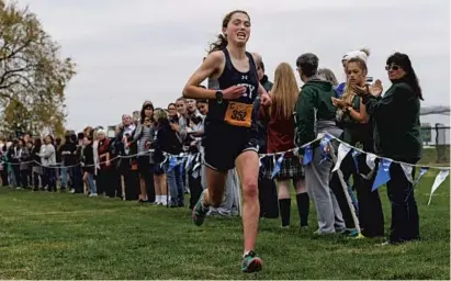  ?? KENNETH K. LAM/BALTIMORE SUN ?? Key School’s Storrie Kulynych-Irvin heads to the finish line as the winner of the IAAM girls cross country championsh­ip race.