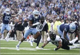  ?? GERRY BROOME — THE ASSOCIATED PRESS ?? North Carolina running back Ty Chandler (19) runs for a touchdown as offensive lineman Jordan Tucker (74) blocks Wake Forest defensive back Traveon Redd (17) during the second half Saturday in Chapel Hill, N.C.