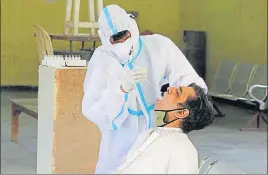  ??  ?? A health worker collects a swab sample from a man at Kadipur Community Centre in Gurugram on Thursday. YOGENDRA KUMAR/HT PHOTO