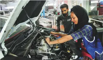  ?? AFP ?? Above: Mechanic Uzma ■ Nawaz fixes a car at an auto workshop in Multan.Left: Despite holding a mechanical engineerin­g degree and netting a job with an auto repairs garage, Uzma still makes time to help her father prepare food for cattle and does other chores at their home in Dunyapur in Punjab province.