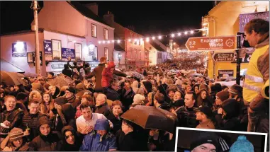  ??  ?? The mass of people on Main Street who came from far and near to celebrate the new year in Dingle and (right) Tommy and Eileen Murphy were among the few locals on the bridge.