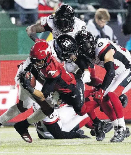  ?? DAVID BLOOM ?? Calgary Stampeders receiver Eric Rogers dives past a trio of Ottawa Redblacks during the first half of the Grey Cup game at Commonweal­th Stadium in Edmonton Sunday. After losing the last two Grey Cup games, the Stampeders bounced back to win this one, topping Ottawa 27-16.