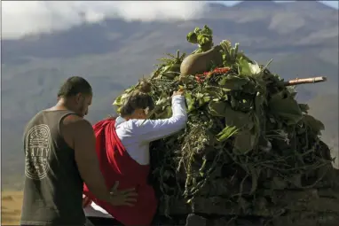  ?? CALEB JONES — THE ASSOCIATED PRESS FILE ?? In this Sunday file photo, Native Hawaiian activists pray at the base of Hawaii’s Mauna Kea, background. For activists who say they’re protecting Mauna Kea, the fight against the proposed Thirty Meter Telescope is a boiling point in Hawaiian history: the overthrow on the Hawaiian kingdom, battles over land, water and developmen­t and questions about how the islands should be governed.