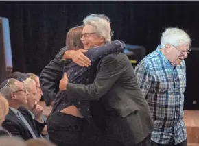  ?? GREG LOVETT/THE PALM BEACH POST ?? Congregant­s hug Tuesday during an event to show solidarity for Israel at Congregati­on B’Nai Israel in Boca Raton.