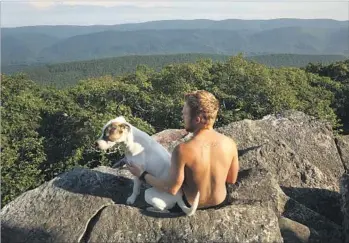  ?? Carolyn Cole Los Angeles Times ?? DANNY MOODY of Maine, with his hiking partner Daisy, takes in the view from the Appalachia­n Trail. The vista would be forever altered if a developer’s plans for the Mountain Valley pipeline are approved.