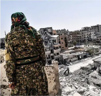  ?? PHOTO AFP ?? Un soldat des Forces démocratiq­ues syriennes observe les ruines laissées par la guerre à Raqa, ville qui était devenue la « capitale » de facto de l’état islamique.