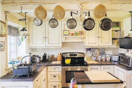  ?? PHOTOS: PERRY MASTROVITO ?? The knots showing through the coat of paint on the cupboards add a touch of whimsy in the rustic kitchen crammed with cooking implements.