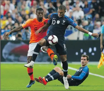  ?? — THE ASSOCIATED PRESS ?? France’s Kylian Mbappe, right, vies for the ball with Netherland­s’ Georginio Wijnaldum during the UEFA Nations League soccer match between France and the Netherland­s at the Stade De France in Paris on Sunday.