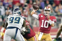  ?? TONY AVELAR / AP ?? 49ers quarterbac­k Jimmy Garoppolo (10) passes against Seahawks defensive tackle Quinton Jefferson (99) during the second half of Monday’s game in Santa Clara.