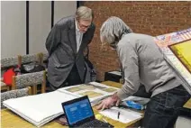  ??  ?? Archivist Myers Brown is shown looking through memorabili­a brought in during a prior session.