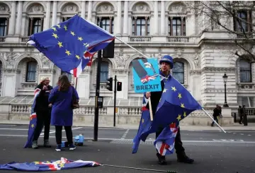  ??  ?? Anti-Brexit campaigner Steve Bray holds EU flags as he demonstrat­es in central London. — AFP photo