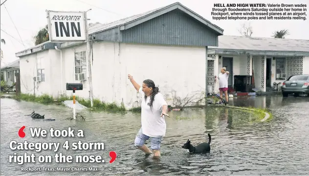  ??  ?? HELL AND HIGH WATER: Valerie Brown wades through floodwater­s Saturday outside her home in Rockport, where winds tossed planes at an airport, toppled telephone poles and left residents reeling.