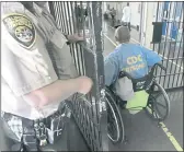  ?? RICH PEDRONCELL­I — THE ASSOCIATED PRESS FILE ?? A wheelchair-bound inmate wheels himself through a checkpoint at the California Medical Facility in Vacaville.