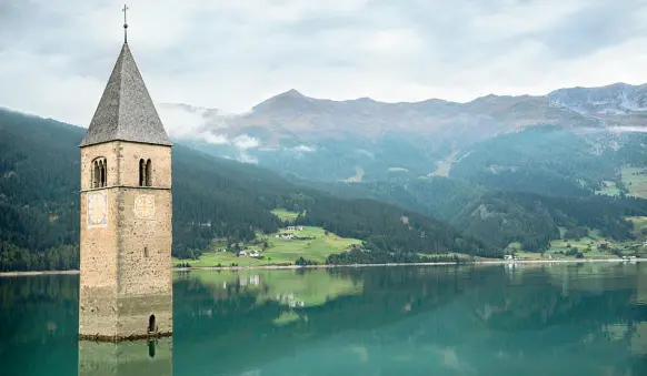  ??  ?? Il campanile Dal lago di Curon svetta il celebre campanile diventano immagine iconica, a perenne ricordo del paese sommerso e cancellato dall’acqua