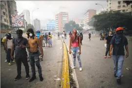  ?? ARIANA CUBILLOS — THE ASSOCIATED PRESS ?? Anti-government demonstrat­ors block a street during clashes Thursday with National Guards in Caracas, Venezuela. President Nicolás Maduro and his opponents faced a crucial showdown as the country’s opposition called for a 24-hour national strike.