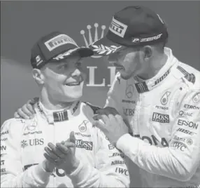  ?? PAUL CHIASSON, THE CANADIAN PRESS ?? Canadian Grand Prix winner Mercedes driver Lewis Hamilton, of Great Britain, celebrates with teammate and second-place finisher Valtteri Bottas, of Finland, June 11 in Montreal.