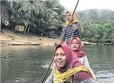  ??  ?? Young women paddle a boat near Gajah Bertalut village in Riau province of Sumatra, Indonesia.