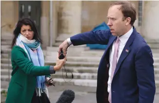  ?? (Tom Nicholson/Reuters) ?? BRITAIN’S HEALTH SECRETARY Matt Hancock hands a microphone to his aide Gina Coladangel­o, following a television interview outside BBC’s Broadcasti­ng House in London, last month.