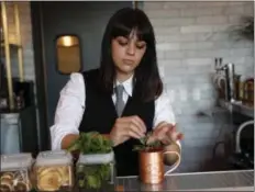  ?? NHAT V. MEYER/ BAY AREA NEWS GROUP ?? Bartender Sabrina Dawoud prepares a Seasonal Mule; Tito’s vodka, cranberry hibiscus shrub, and Top Hat ginger beer, for $13, at La Rinconada Bar inside The Catamount in Los Gatos, Calif.