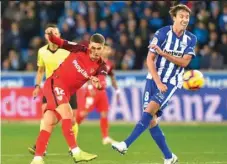  ?? (AFP) ?? Sevilla’s Andre Silva (left) shoots past Alaves’ Pina during the La Liga match at the Mendizorro­za stadium in Vitoria, Spain on Sunday night.