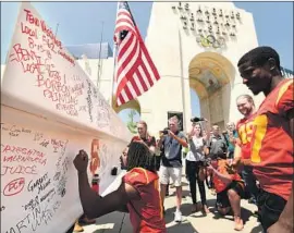  ?? Wally Skalij Los Angeles Times ?? USC SAFETY Marvell Tell signs a metal beam during a media tour of the Coliseum. Fans will notice many changes at the stadium as renovation­s continue.