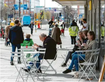  ?? Foto: Ali Lorestani, dpa ?? Stockholm im Frühjahr: Menschen sitzen in den Straßencaf­és, Masken sind kaum zu sehen. Das skandinavi­sche Land gilt vielen Kritikern der deutschen Corona-Maßnahmen als Vorbild. Doch die Bilanz ist zwiegespal­ten.