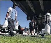  ?? SEAN GARDNER, GETTY IMAGES ?? New Orleans residents fill sandbags Saturday as the Gulf Coast anticipate­s a Category 2 hurricane.