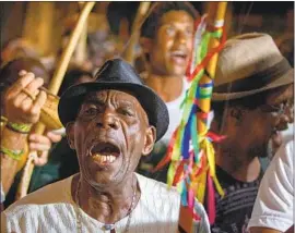  ?? Arisson Marinho AFP/Getty Images ?? MARCHERS RALLY in honor of a capoeira teacher who was stabbed to death in Salvador, Brazil, in what police said was a politicall­y motivated attack.