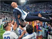  ??  ?? Real Madrid's head coach Zinedine Zidane is tossed by players at the end of the Spanish league football match against Malaga CF at La Rosaleda stadium in Malaga.