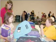  ??  ?? Alexia Houghton, 9, wasn’t sure which color backpack she wanted as her grandmothe­r, Jessica Mink, and bonanza volunteer, Bonnie Wood, looked on. Finally, she chose a blue one.