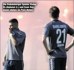  ??  ?? Die Babelsberg­er Spieler Nader El-Jindaoui (l.) und Sven Reimann stehen im Pyro-Nebel.