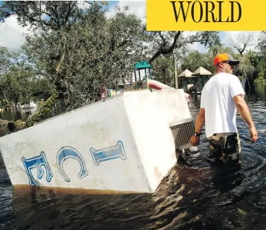  ?? BRIAN BLANCO / GETTY IMAGES ?? Waist-deep in flood water, Jason Coker drags an ice machine to dry land at the Peace River Campground in Arcadia, Fla. on Tuesday. Seven deaths in Florida have been blamed on Hurricane Irma, along with four in South Carolina and two in Georgia. At...