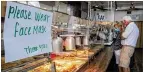  ?? BEN GRAY FOR THE AJC ?? FACE MASKS: Sheets of acrylic separate the food from the hungry lunch crowd at Matthews Cafeteria on Main Street in Tucker in July.