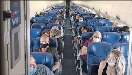  ?? Photograph­s by Christophe­r Reynolds Los Angeles Times ?? MASKED PASSENGERS fill a Southwest Airlines flight from Burbank to Las Vegas on June 3, with middle seats left empty.